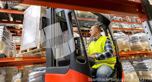 Image of loader operating forklift at warehouse