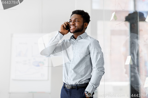 Image of businessman calling on smartphone at office