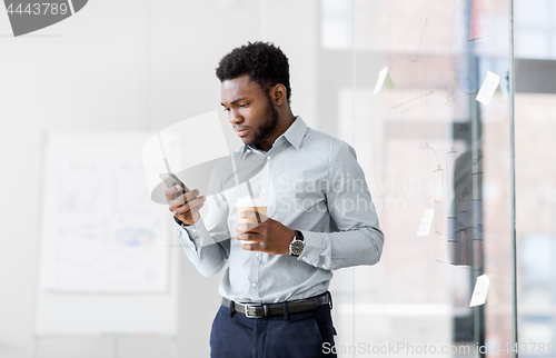 Image of businessman with smartphone and coffee at office