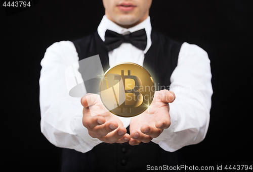 Image of close up of magician with bitcoin over black