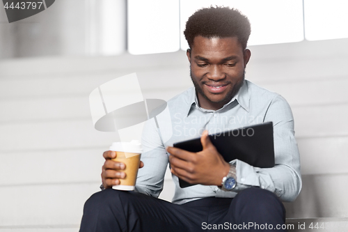 Image of businessman with tablet pc and coffee on stairs