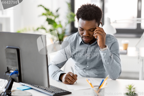 Image of businessman calling on smartphone at office