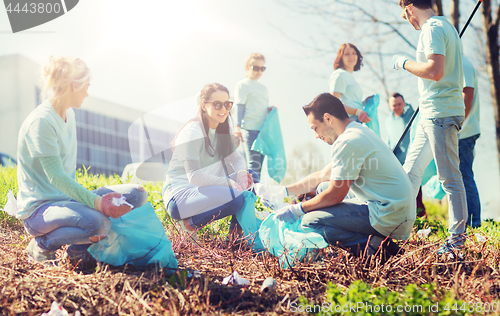 Image of volunteers with garbage bags cleaning park area