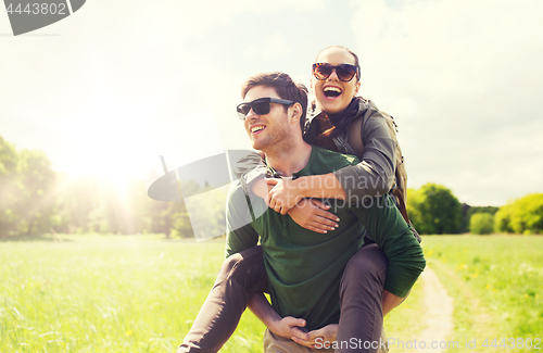 Image of happy couple with backpacks having fun outdoors