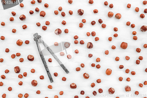 Image of Nutcracker and hazelnuts on white wooden background