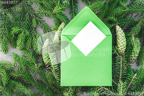 Image of Fir branches and green envelope with blank greeting card