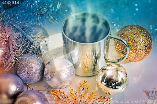 Image of Metal mug with hot steaming coffee, Christmas balls, Christmas tree.