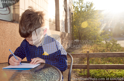 Image of Boy doing homework outdoors