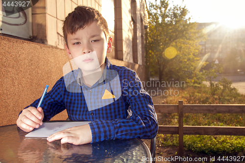 Image of Boy doing homework outdoors