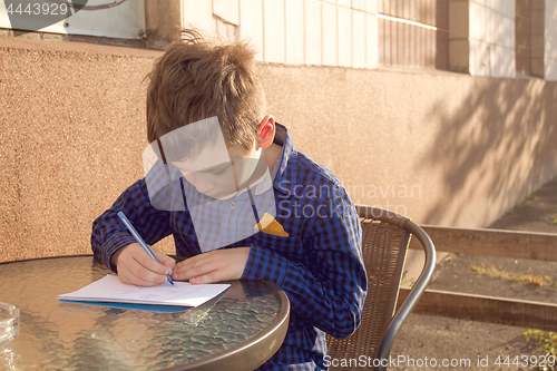 Image of Boy doing homework outdoors