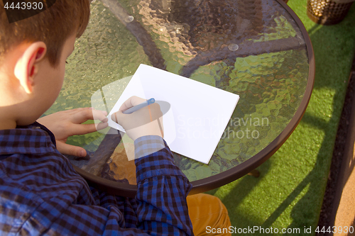 Image of Boy doing homework outdoors