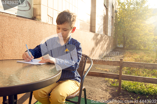 Image of Boy doing homework outdoors