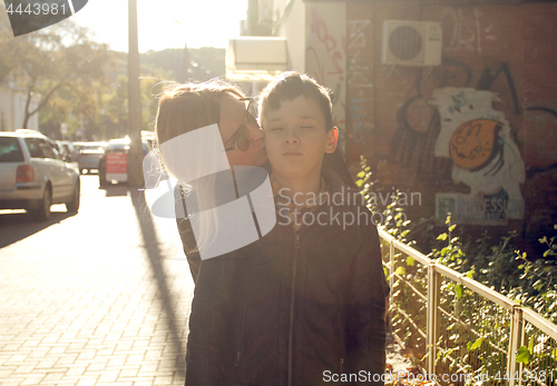 Image of Mother is kissing her son on the cheek