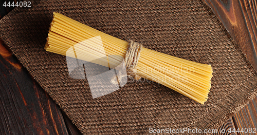 Image of Bunch of spaghetti on burlap textile