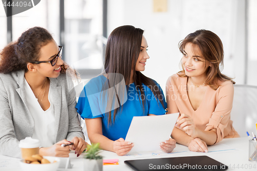 Image of businesswomen discussing papers at office