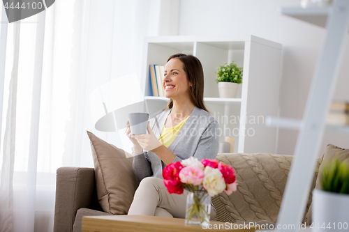 Image of happy woman drinking tea or coffee at home