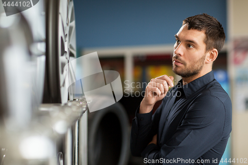 Image of male customer choosing wheel rims at car service