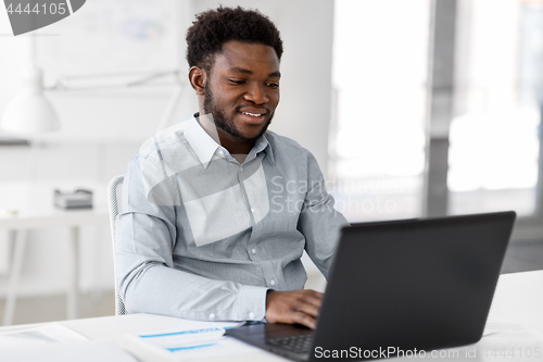 Image of african american businessman with laptop at office