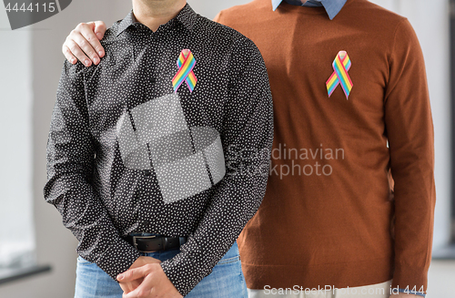 Image of close up of couple with gay pride rainbow ribbons