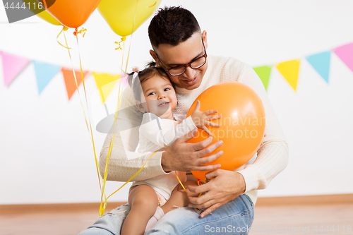 Image of father and daughter with birthday party balloons