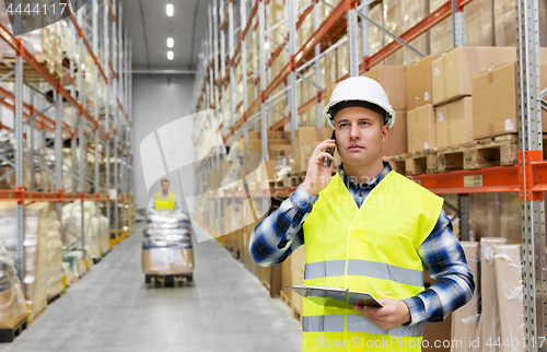 Image of businessman calling on smartphone at warehouse