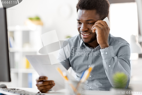 Image of businessman calling on smartphone at office