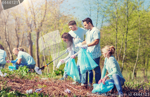 Image of volunteers with garbage bags cleaning park area