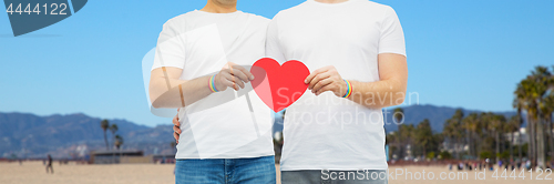 Image of couple with gay pride rainbow wristbands and heart