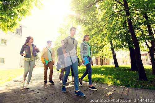 Image of group of happy teenage students walking outdoors