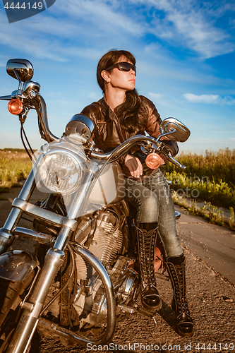 Image of Biker girl sitting on motorcycle