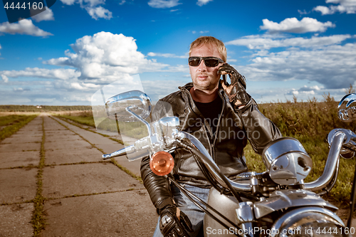 Image of Biker talking on a smartphone.