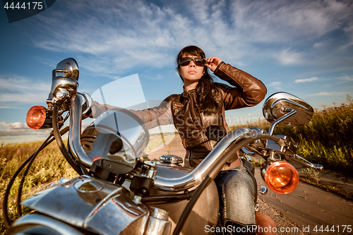 Image of Biker girl sitting on motorcycle