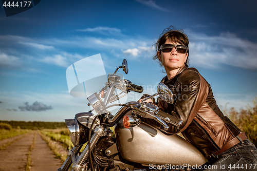 Image of Biker girl sitting on motorcycle