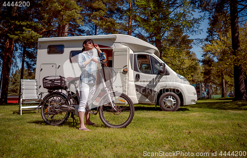 Image of Woman on electric bike resting at the campsite VR Caravan car Va