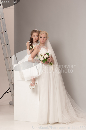 Image of Little pretty girls with flowers dressed in wedding dresses