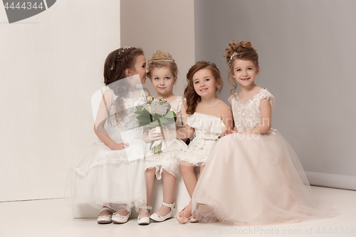 Image of Little pretty girls with flowers dressed in wedding dresses