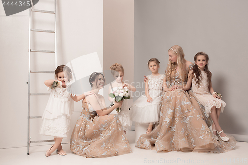 Image of Little pretty girls with flowers dressed in wedding dresses