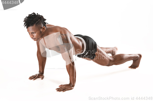 Image of Muscular young man doing press-ups