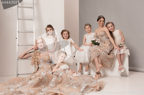 Image of Little pretty girls with flowers dressed in wedding dresses
