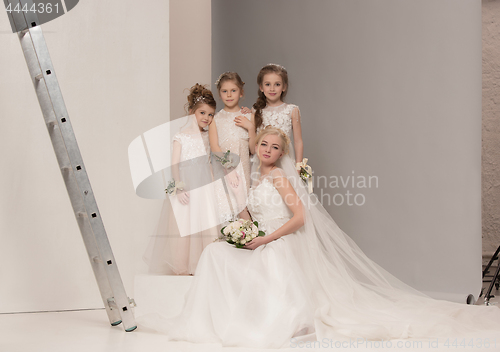 Image of Little pretty girls with flowers dressed in wedding dresses