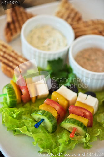 Image of toast with cheese vegetables and olive on the stick