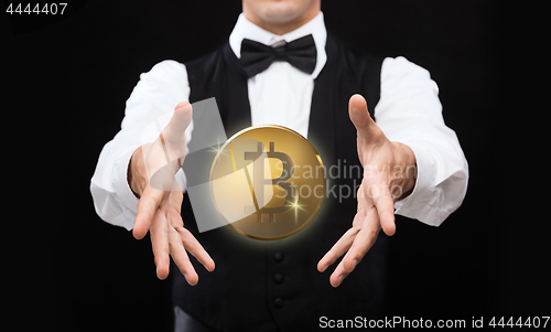 Image of close up of magician with bitcoin over black