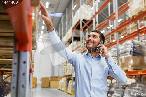 Image of businessman calling on smartphone at warehouse