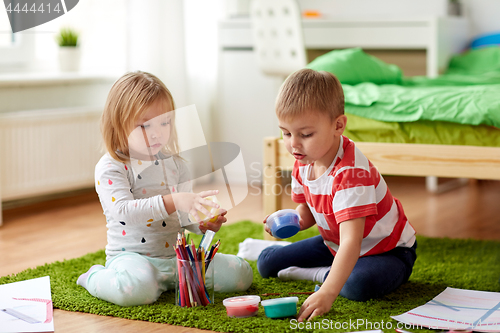 Image of kids with modelling clay and crayons at home