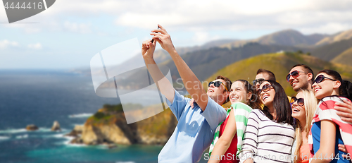 Image of group of happy friends taking selfie by cell phone