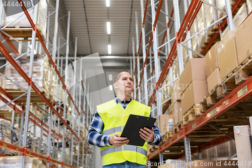 Image of warehouse worker with clipboard in safety vest