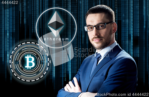 Image of businessman with cryptocurrency holograms