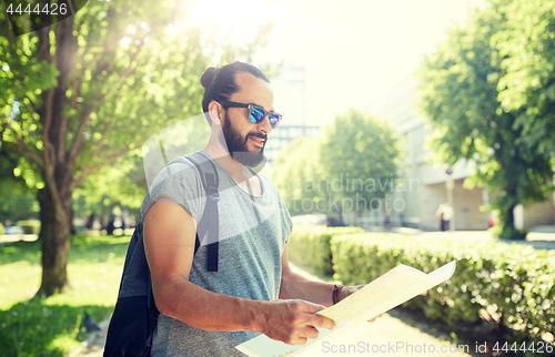 Image of man traveling with backpack and map in city