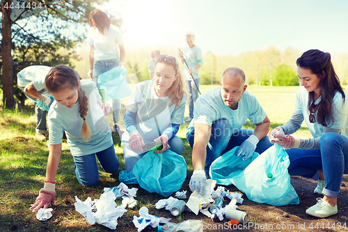 Image of volunteers with garbage bags cleaning park area