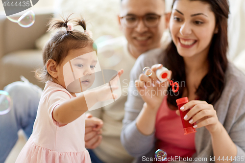 Image of family with soap bubbles playing at home